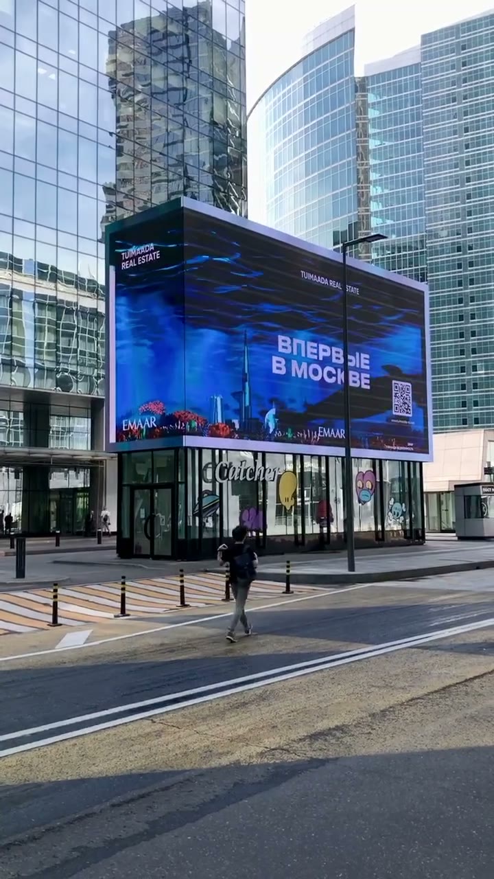 A screen with the words First time in Moscow on a Moscow City building