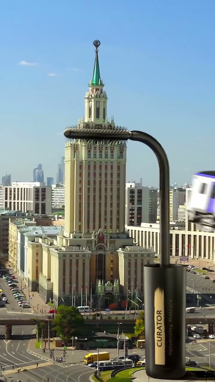 The mascara brush bends over the spire of a high-rise in a real city setting